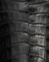 Close-up of textured brown ostrich leather, showing characteristic raised bumps and natural grain pattern.