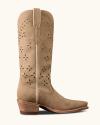 Beige suede cowboy boot with floral cutout patterns, pointed toe, and a stacked wooden heel, shown in a side view against a plain background.