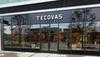 Storefront of Tecovas, featuring large glass windows and double glass doors, with the brand name displayed above the entrance on a black sign.