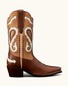 Brown and tan cowboy boot with decorative white and beige stitching, paisley patterns, and arrow designs on the shaft. The boot has a pointed toe and a stacked heel.