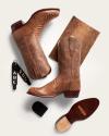 A pair of brown snakeskin cowboy boots, a matching snakeskin wallet, two black keychains with "ABC" initials, and a leather sole care kit arranged on a white background.