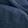 Close-up of dark blue denim fabric with visible stitching and fold lines.