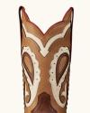 Close-up of the upper part of a brown leather cowboy boot with decorative white and dark brown stitching and patterns.
