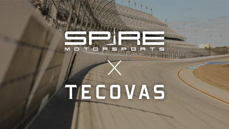 A racetrack with empty grandstands; overlaid text reads "Spire Motorsports x Tecovas.