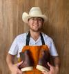 man holding pair of boots in hands