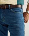 A person wearing blue jeans, a brown belt, a two-tone shirt, and a wristwatch, with the focus on their waist and right hand.