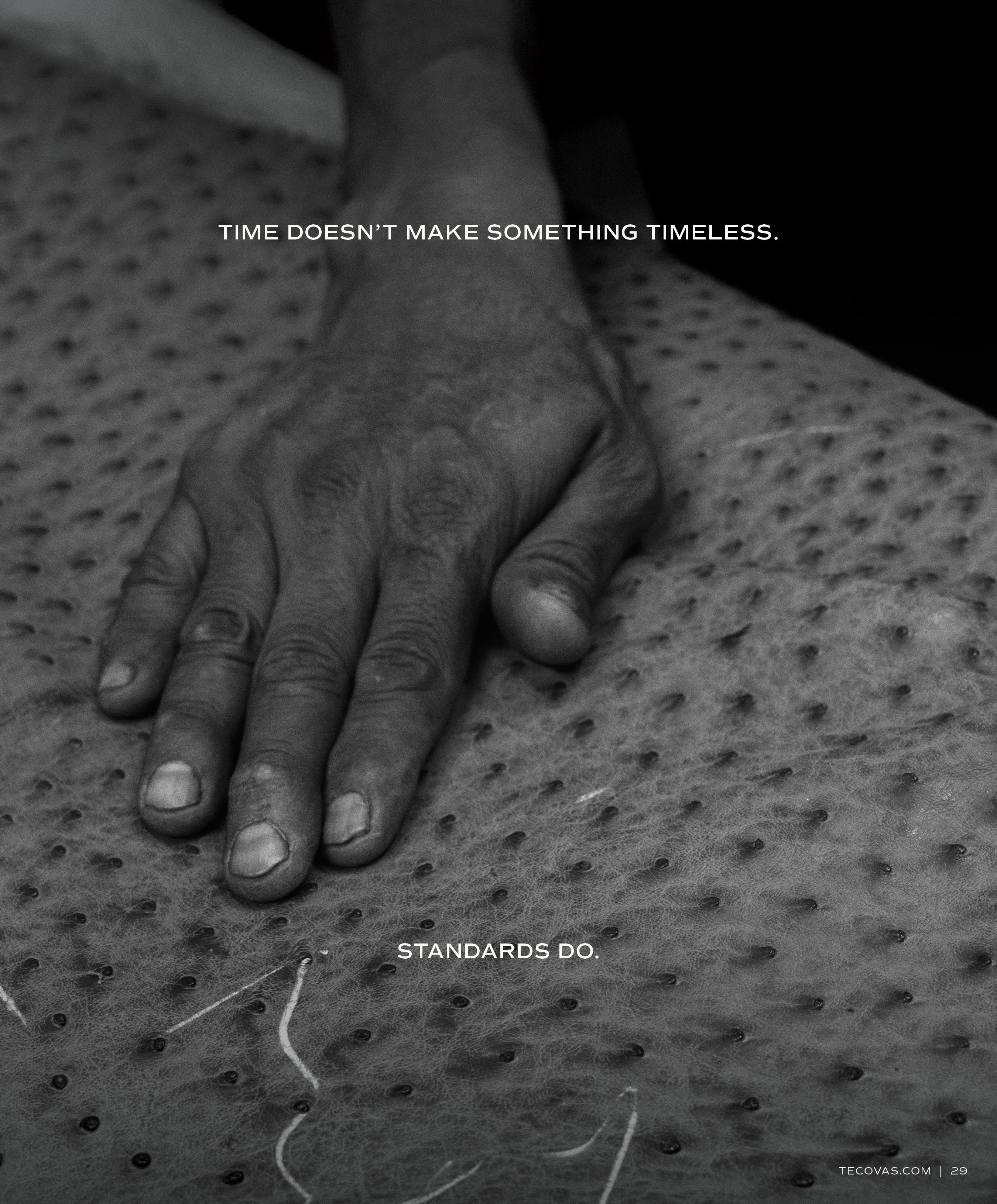 A black and white close-up of a weathered hand resting on a piece of full-quill ostrich leather. Overlaid text reads: 'TIME DOESN'T MAKE SOMETHING TIMELESS. STANDARDS DO.'
