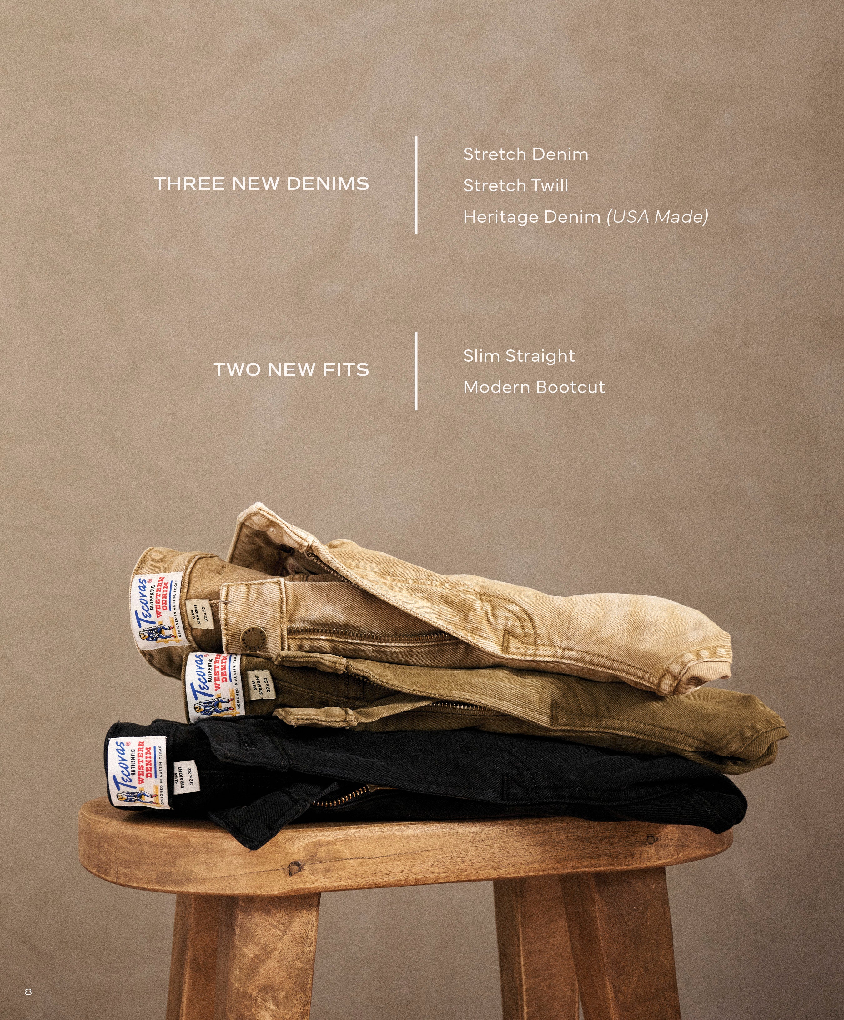 A stack of three pairs of jeans in tan, olive, and black sitting on a wooden stool. Text outlines new denim fabrics and fits: THREE NEW DENIMS: Stretch Denim, Stretch Twill, Heritage Denim (USA Made) and TWO NEW FITS: Slim Straight, Modern Bootcut.