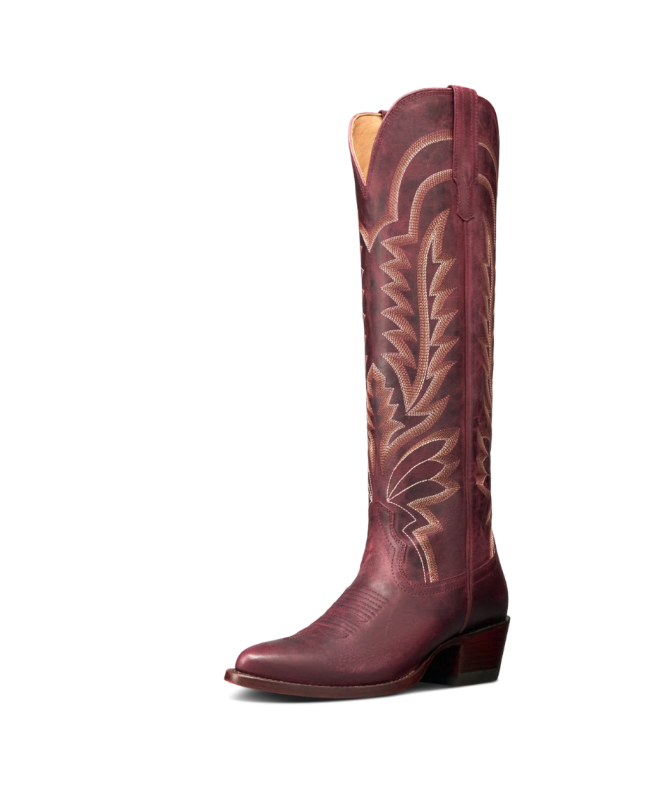 The Abby in Wine Goat. A single tall, maroon cowboy boot with decorative stitching, a pointed toe, and a low angled heel stands against a plain white background—evoking the rich hue of Wine Goat.
